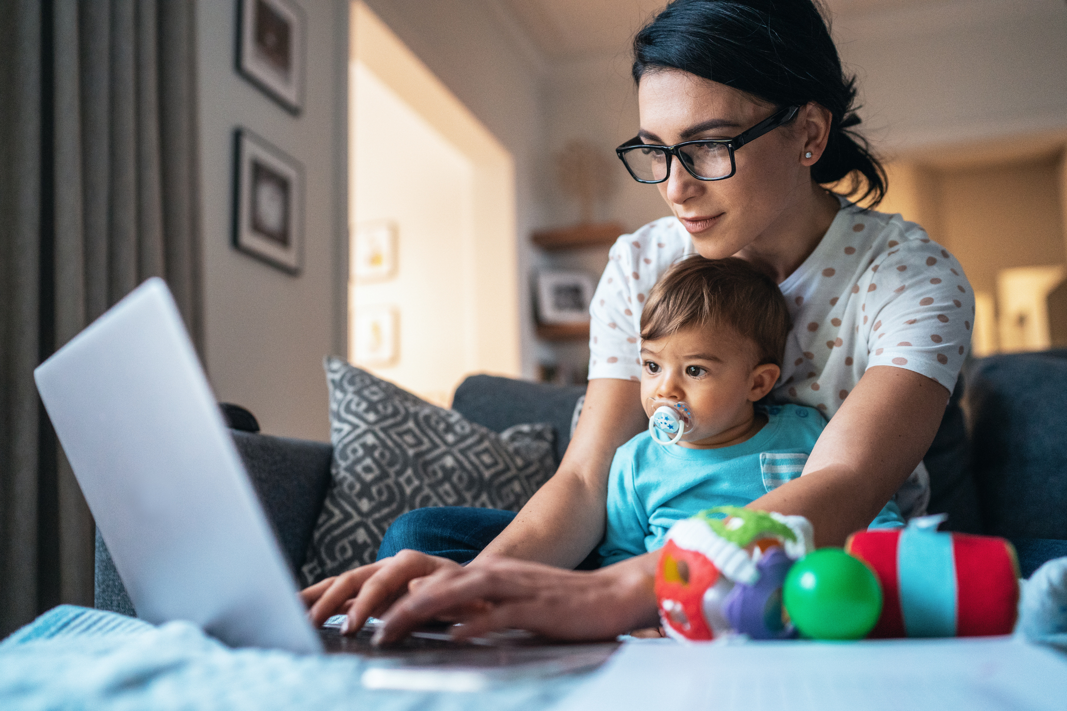 woman working at her laptop with a baby